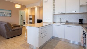 Una cocina moderna con armarios blancos, una isla integrada y una cafetera.