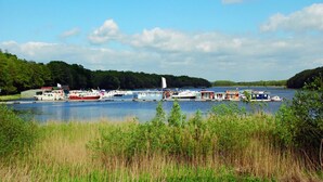Ein Yachthafen mit verschiedenen anlegenden Booten, umgeben von üppiger Vegetation und blauem Himmel.