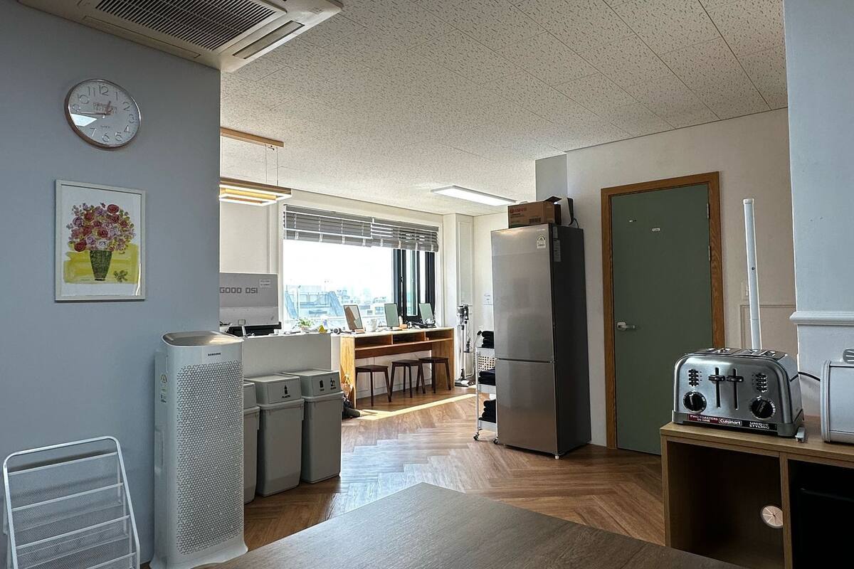 A modern kitchen with a wooden countertop, a refrigerator, a toaster, and a window with a view.