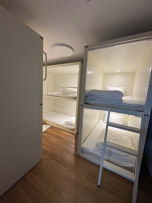 A room with two bunk beds, wooden flooring, and a white door. - K Wave Guesthouse Ony Female In Hongdae 2 (Seoul)
