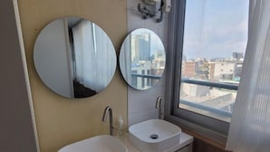 A bathroom with two sinks, a mirror, and a window with a view of buildings. - K Wave Guesthouse Ony Female In Hongdae 2 (Seoul)