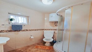 A bathroom with a toilet, a sink, a shower, and a window with curtains. - Hvar spa & apartment-2 Bedroom-Terrace/Sea View 4 (Vrboska)