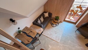Ein modernes Wohnzimmer mit einer Couch, einem Couchtisch aus Holz und einer Treppe, die in eine andere Ebene führt.