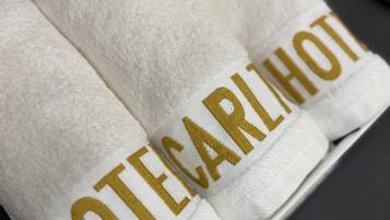 A set of white towels with the text "TECARLHOT" embroidered in gold.