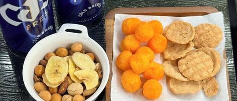 Una bandeja con botanas y un tazón de nueces y rodajas de plátano.