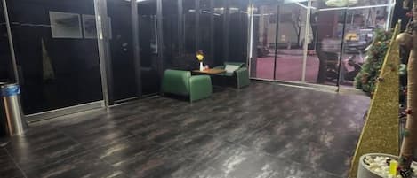 A lobby with a reception desk, seating area, and a glass partition.