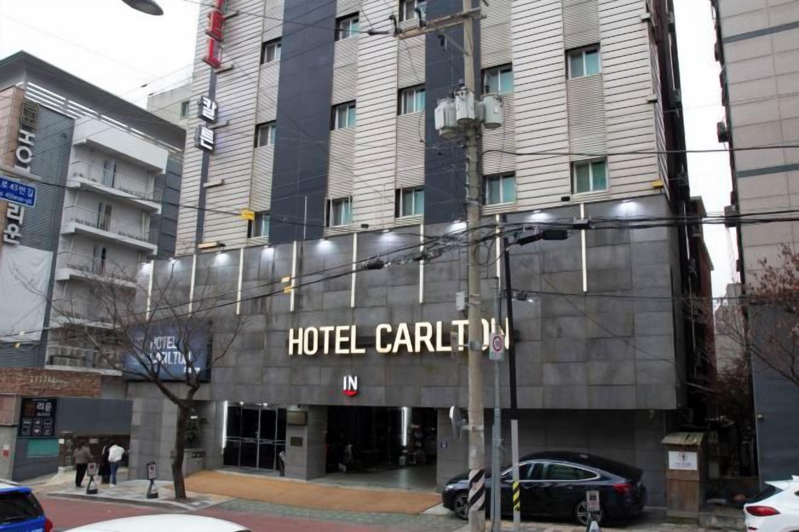 A multi-story building with a sign for 'HOTEL CARLTON IN' indicating a hotel.