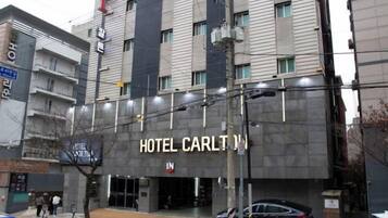 A multi-story building with a sign for 'HOTEL CARLTON IN' indicating a hotel.