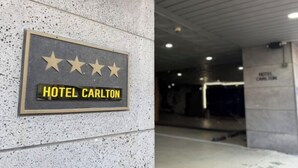 En skylt för HOTEL CARLTON med fyra stjärnor i betyg.
