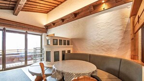 Een gezellig interieur met een ronde tafel, een met kussens beklede bank en een houten stoel.