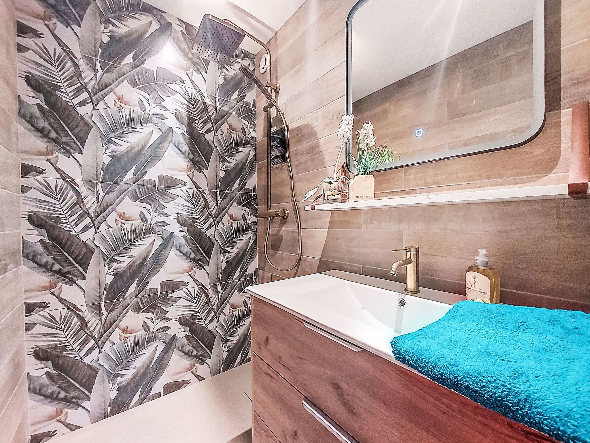 Un bagno con doccia, lavandino e specchio.