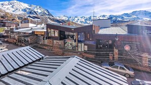Un pueblo montañoso con un edificio destacado que dice 'INTERSPORT' y un cartel que anuncia 'LA FERME DE THORENS'.