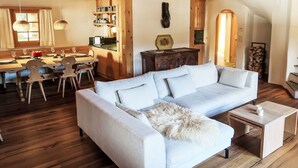 A cozy living room with a sofa, dining table, and kitchen area.