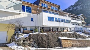 A multi-story building with a ski lift logo, large windows, and a mountain backdrop.
