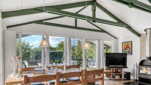 A spacious dining area with wooden furniture and large windows, a television, and a fireplace. - "Inola" - 3.5km from the sea by Interhome (Fjerritslev)