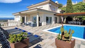 A villa with a swimming pool, outdoor seating, and a view of the mountains. - Belle vue by Interhome (Palau Savardera)
