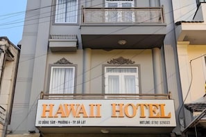Señal de hotel con el nombre 'HAWAII HOTEL' y la dirección '53 ĐÖNG TÁM - PHUÒNG 4 - TR ĐẠI LÀT'.
