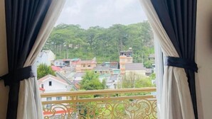 Ein Balkon mit Blick auf ein Wohngebiet und Bäume.