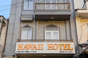 A hotel sign with the name 'HAWAII HOTEL' and contact information.