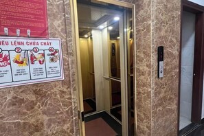 An elevator interior with a sign on the wall and an elevator control panel. - Hawaii Hotel Dalat (Dalat)