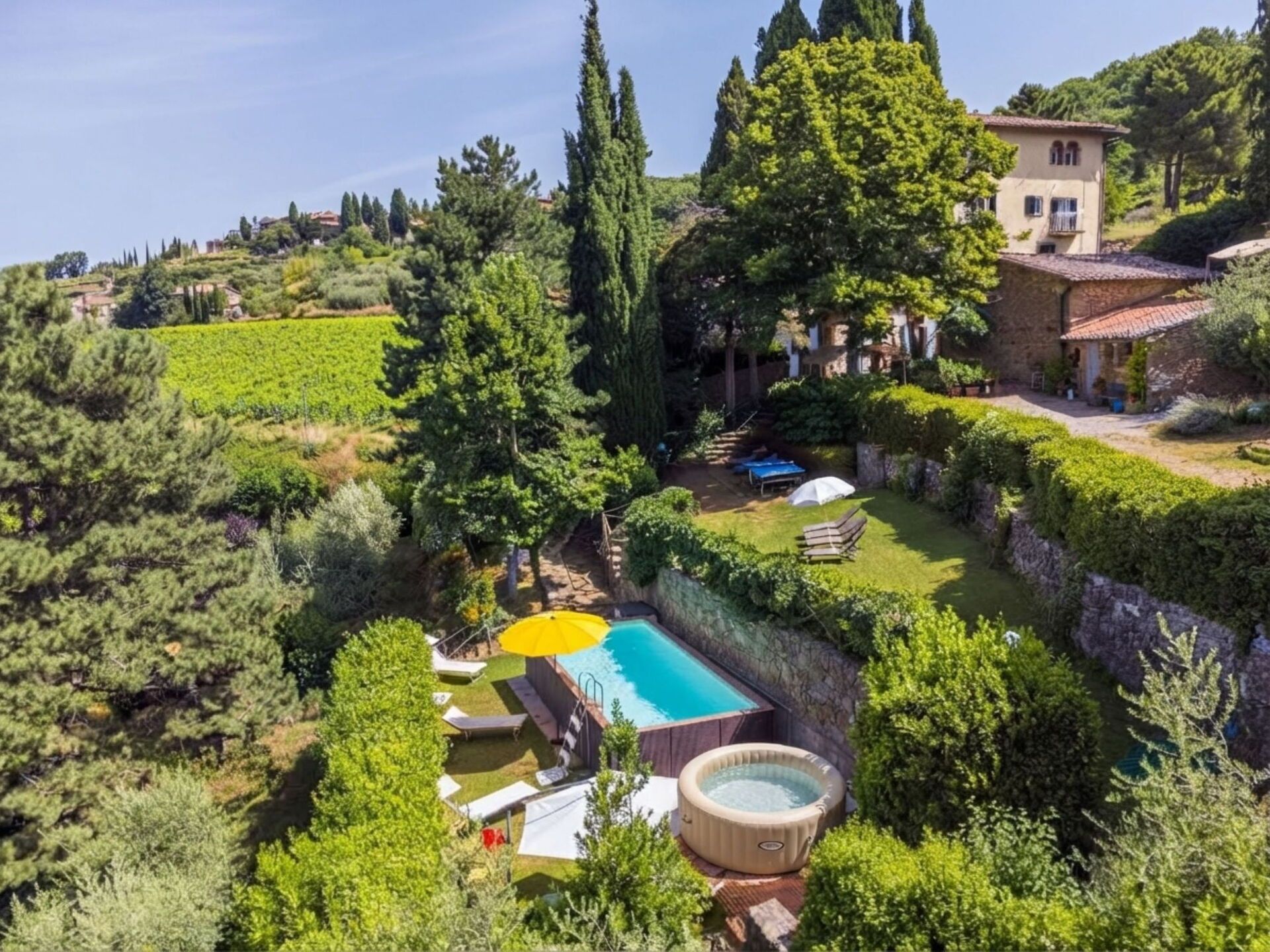 A private garden with a swimming pool, hot tub, and outdoor seating area.