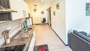 A modern kitchen with wooden cabinets, a stainless steel sink, and a coffee machine.