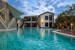 Ein Schwimmbecken mit einem modernen Gebäude im Hintergrund.