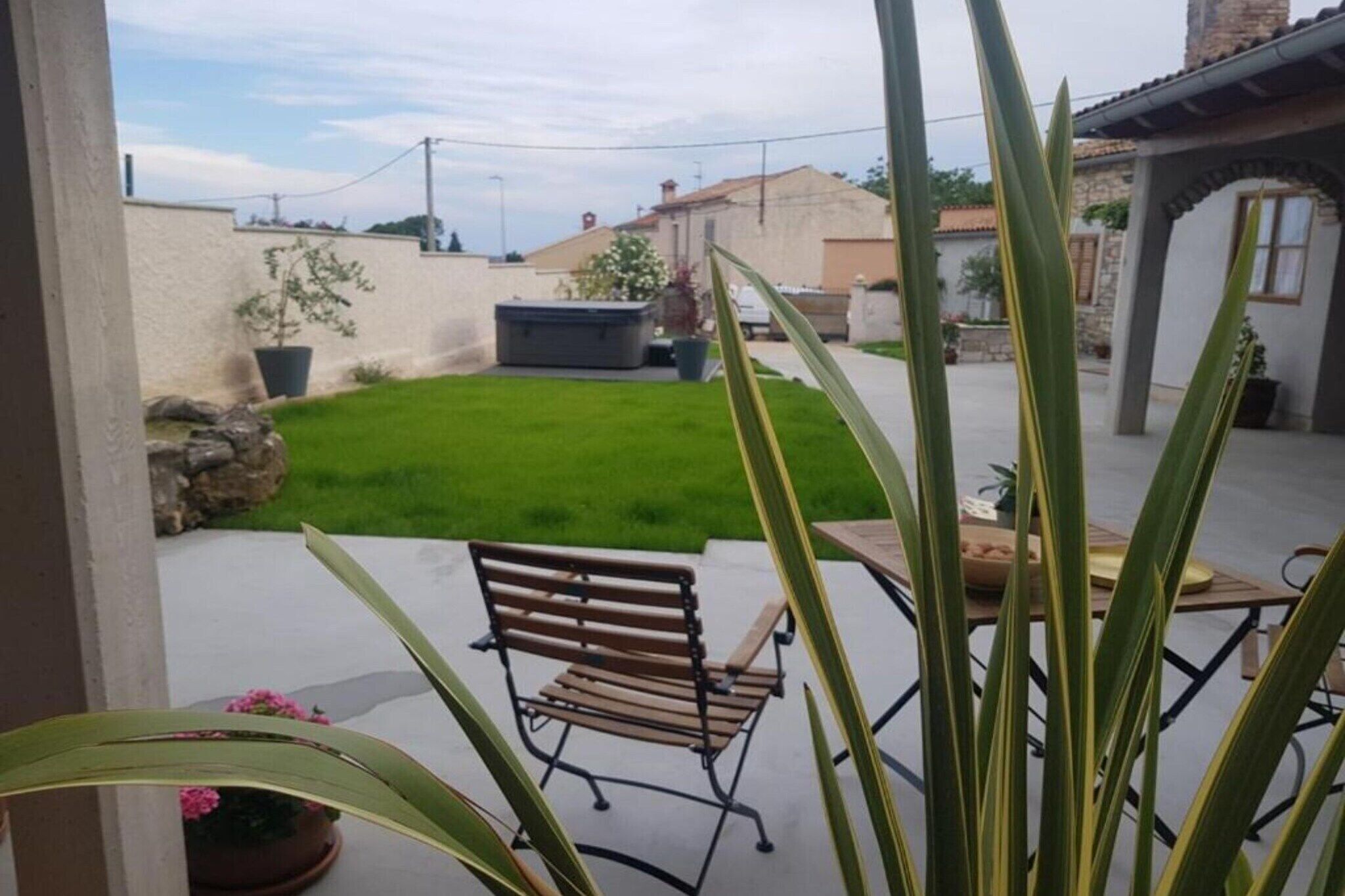 A patio area with a bench, a table, and a small garden.