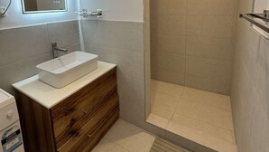 A modern bathroom with a rectangular sink, wooden vanity, and a walk-in shower. - Swansea Coastal Retreat near the sea and IGA (Swansea)