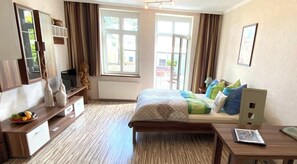 A bedroom with a bed, bedside table, dresser, and a window with curtains. - Usedom, 10 minutes to the beach, Karlshagen, Baltic Sea, Baltic seaside resort (Karlshagen)