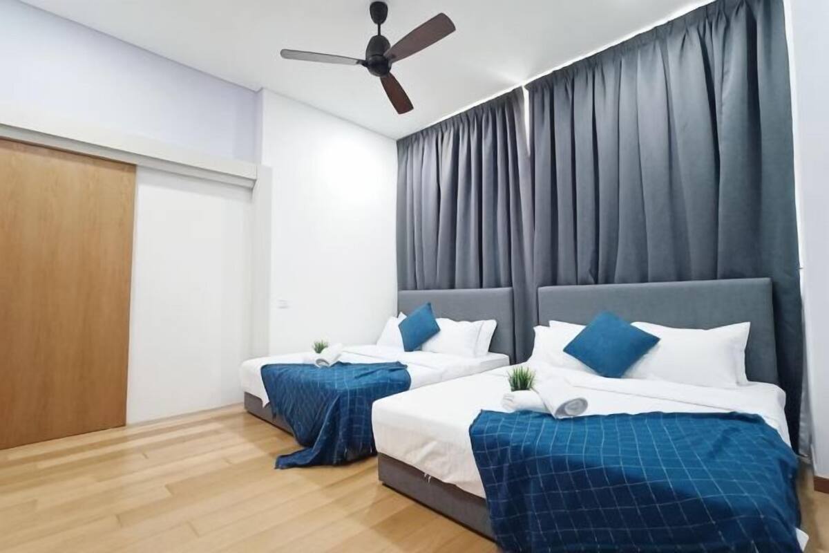 Ein Hotelzimmer mit zwei Betten, einem Deckenventilator und einem großen Fenster mit Vorhängen.