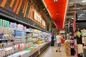 Elintarvikemyymälän käytävä, jonka hyllyt ovat täynnä erilaisia tuotteita.