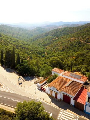 A building with a tiled roof, surrounded by lush greenery and hills in the background. - Studio dos Cantoneiros (Salir)