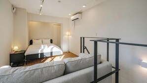 A modern hotel room with a bed, a sofa, a nightstand, and a staircase. - Mi-HOTEL ASAKUSA (Tokyo)