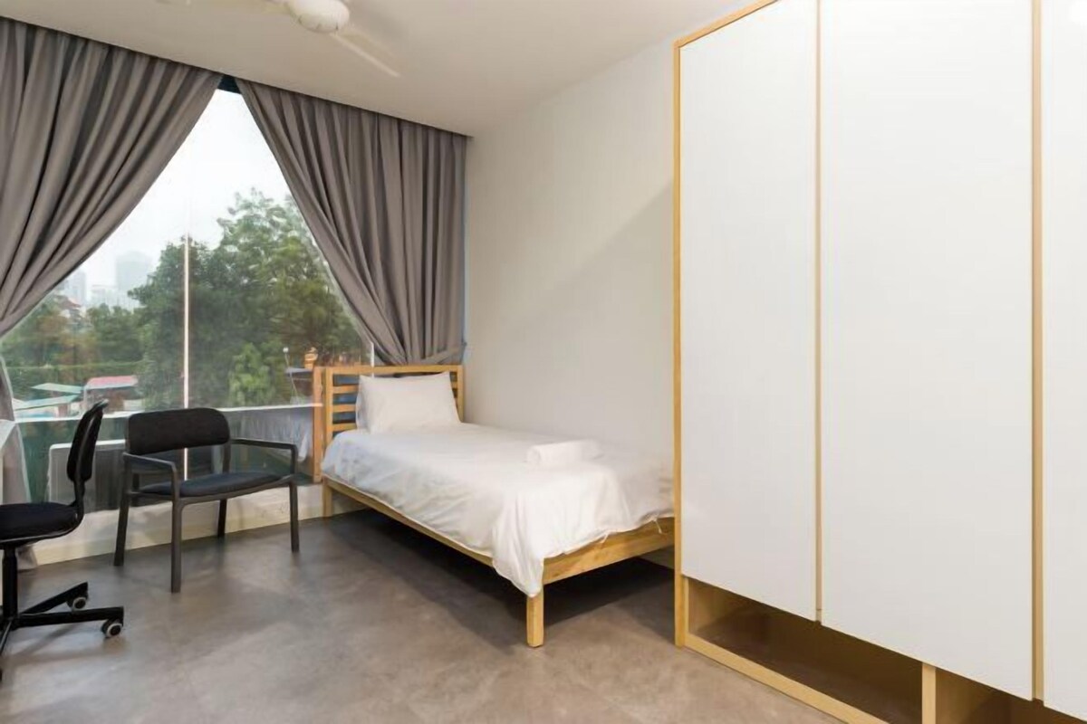 Une chambre à coucher avec un lit, une chaise, un bureau et une armoire.