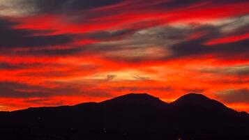 A mountain range silhouette against a vibrant sunset sky.