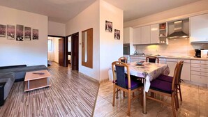 A modern apartment with a dining area, kitchen, and living space.