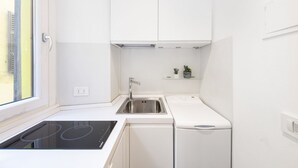 A compact kitchen with a built-in stove, a sink, and a dishwasher. - Easylife - Milano - Carpoforo 5 - Brera (Milano)