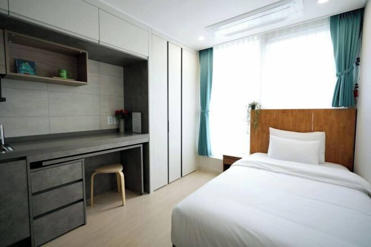 Et moderne hotelværelse med seng, skrivebord og stol.