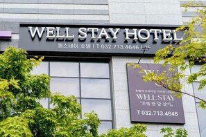 A hotel sign with the name 'WELL STAY HOTEL' and a contact number. - Well Stay Hotel (Incheon)