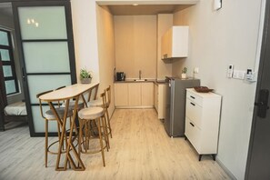 A compact kitchen with a dining area, a refrigerator, and a sink. - LS Sunset Ocean View Homestay - Jesselton Quay (Kota Kinabalu)