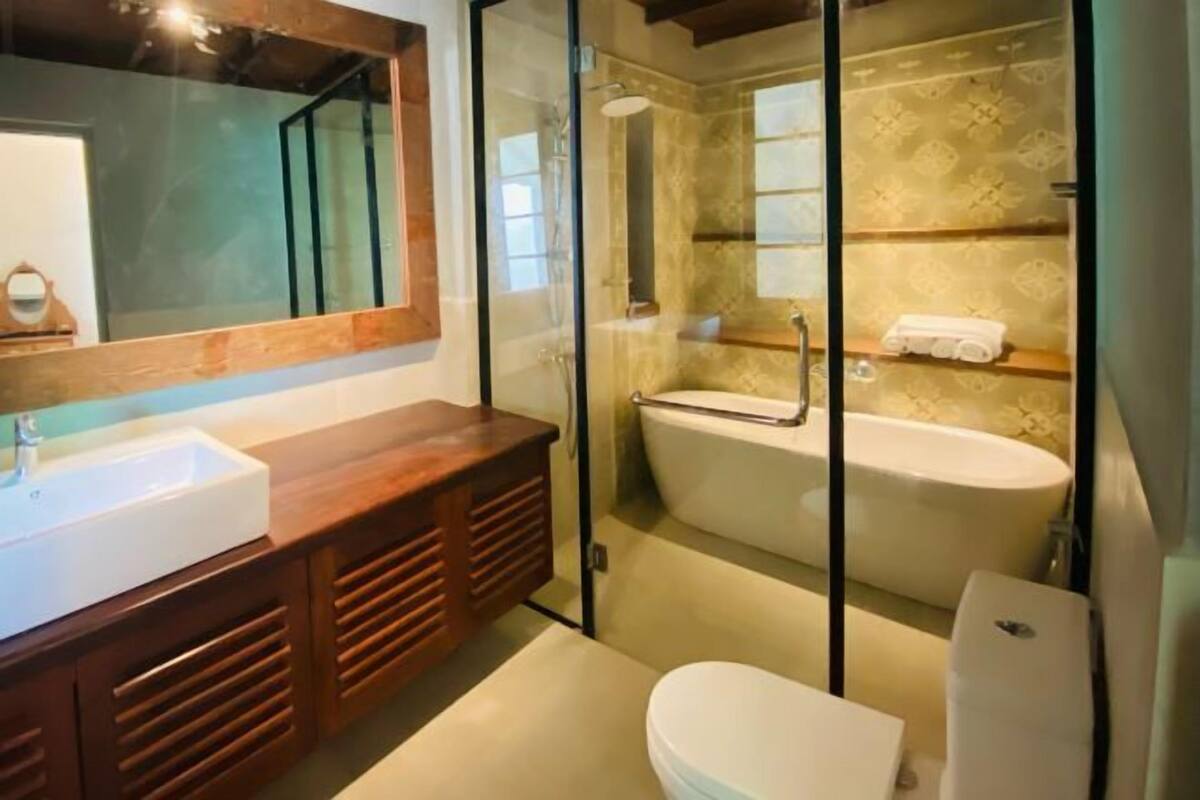 Een badkamer met een douchecabine, een bad, een toilet en een wastafel.