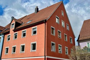 Un edificio rojo con varias ventanas y techo inclinado.