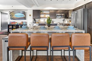 A modern kitchen with granite countertops, stainless steel appliances, and a central island with seating.