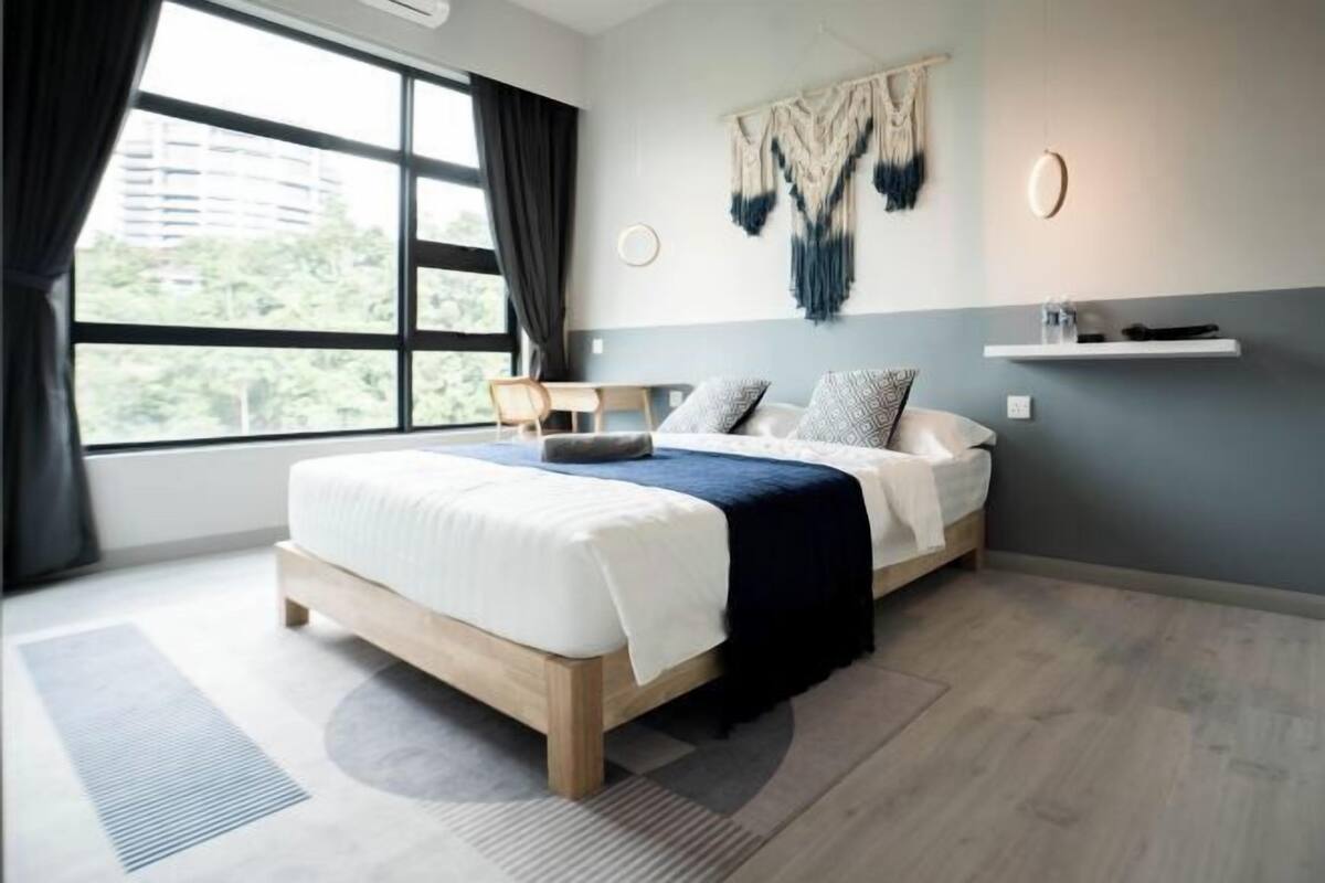 Un dormitorio moderno con una cama grande, un escritorio y vistas a zonas verdes.