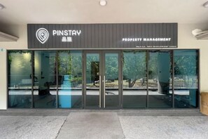 Ingresso di una società di gestione immobiliare, con porta in vetro e cartello.
