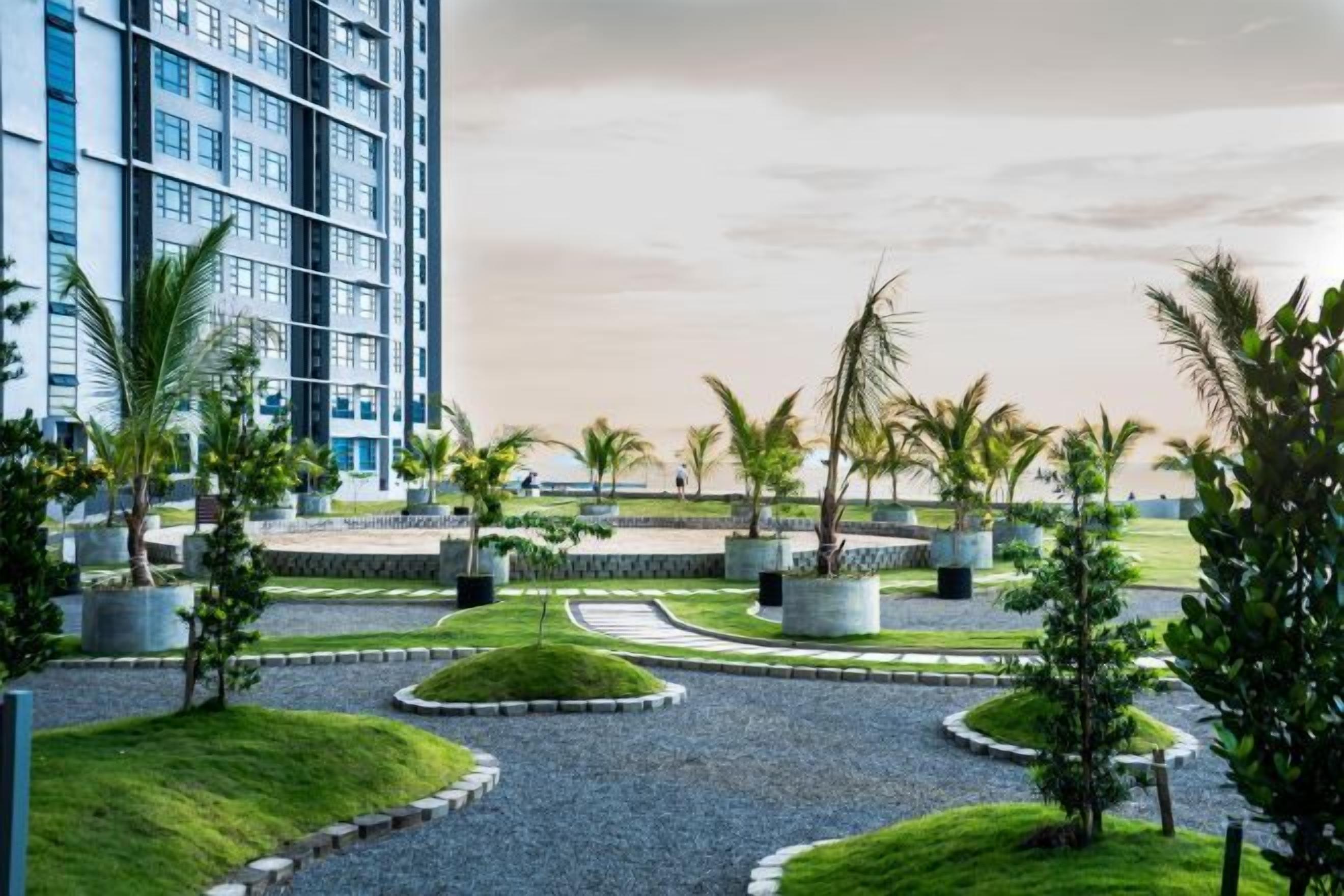 A landscaped area with palm trees, a circular driveway, and a modern building in the background.
