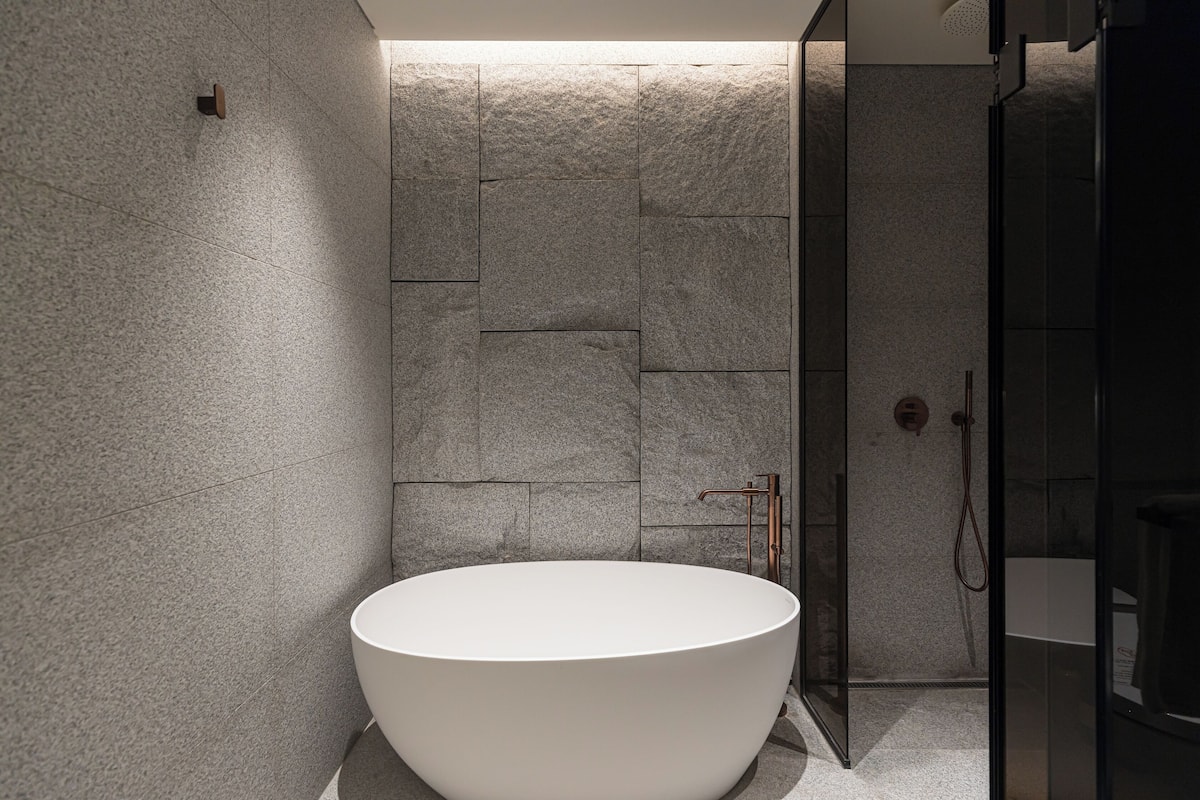 Bathtub dan shower terpisah, sandal, kloset, dan handuk