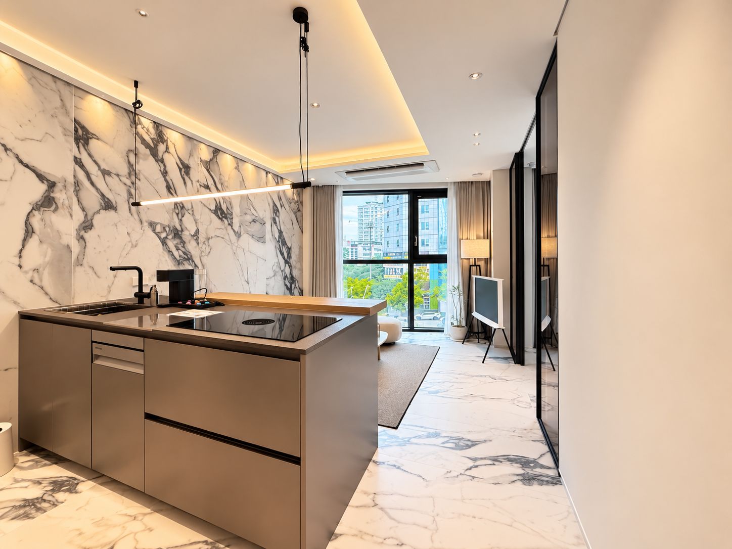 A modern kitchen with a marble backsplash, a built-in stove, and a large window offering a city view.