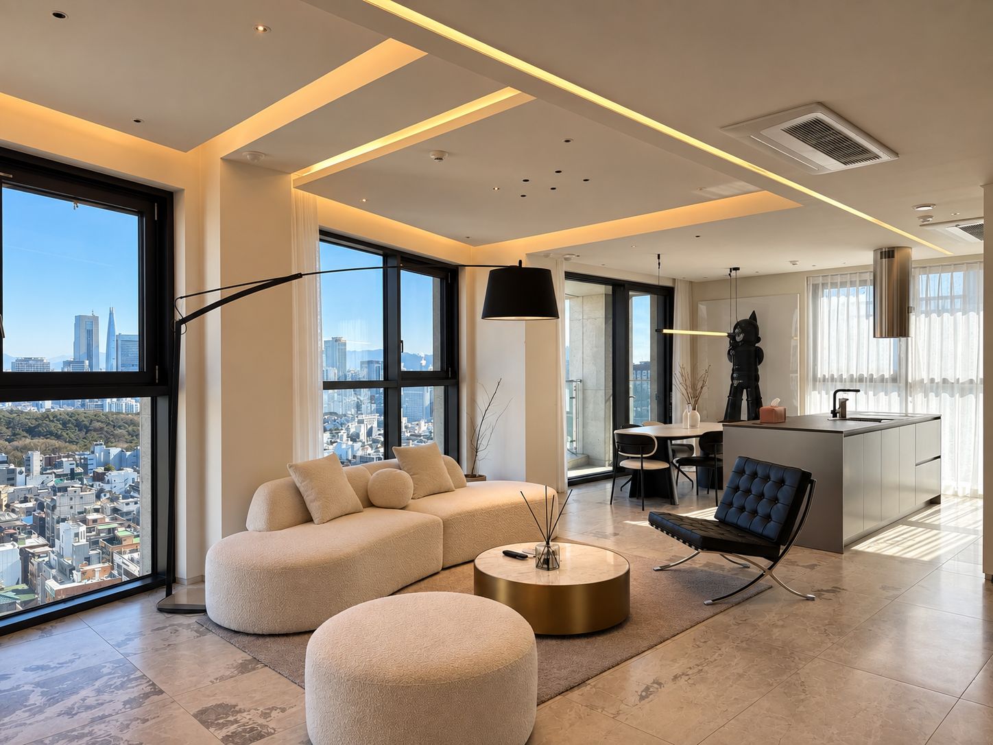 A modern living room with a sofa, ottoman, and coffee table, large windows with a city view, and a dining area with a kitchen island.
